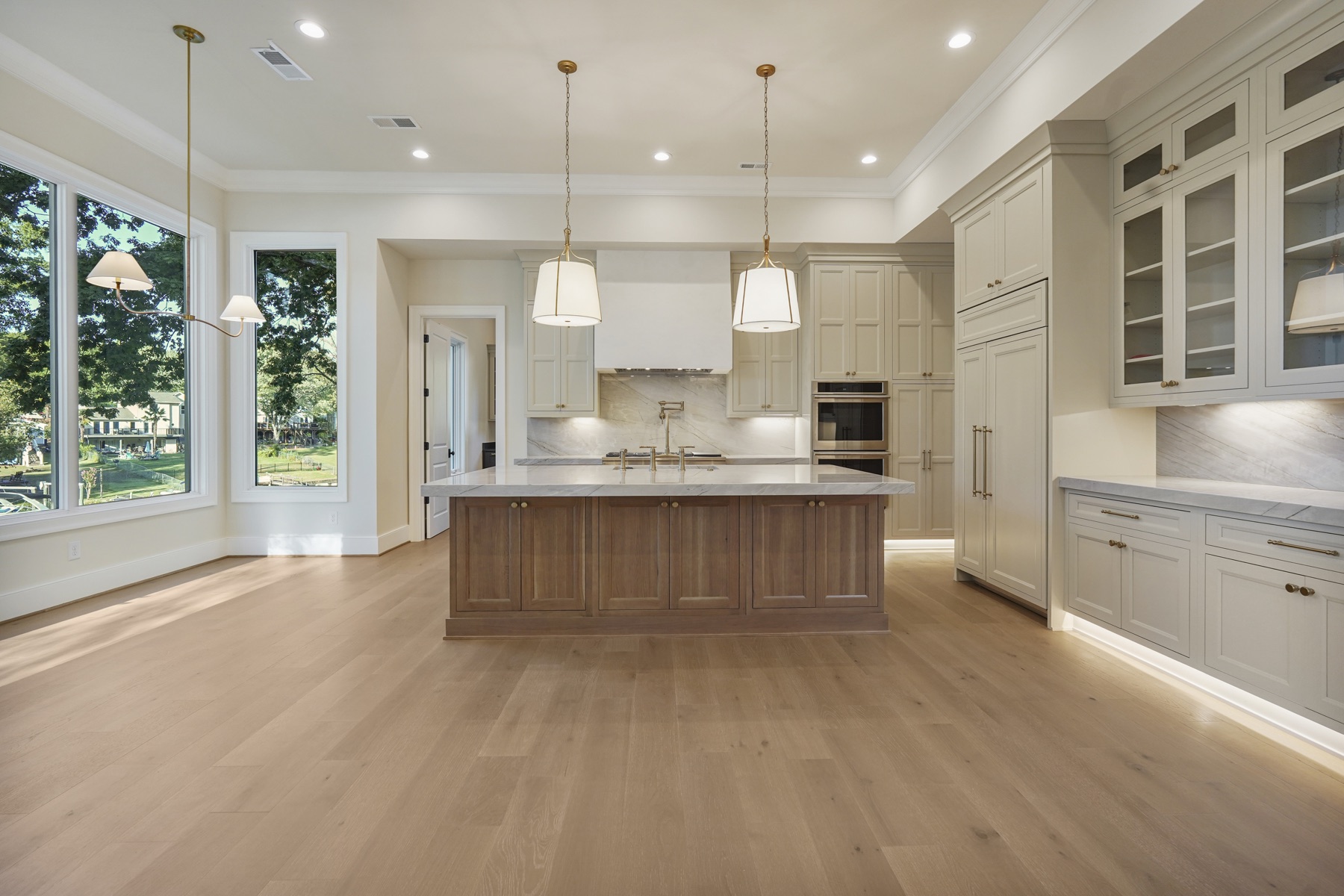 Kitchen island beside floor-to-ceiling windows