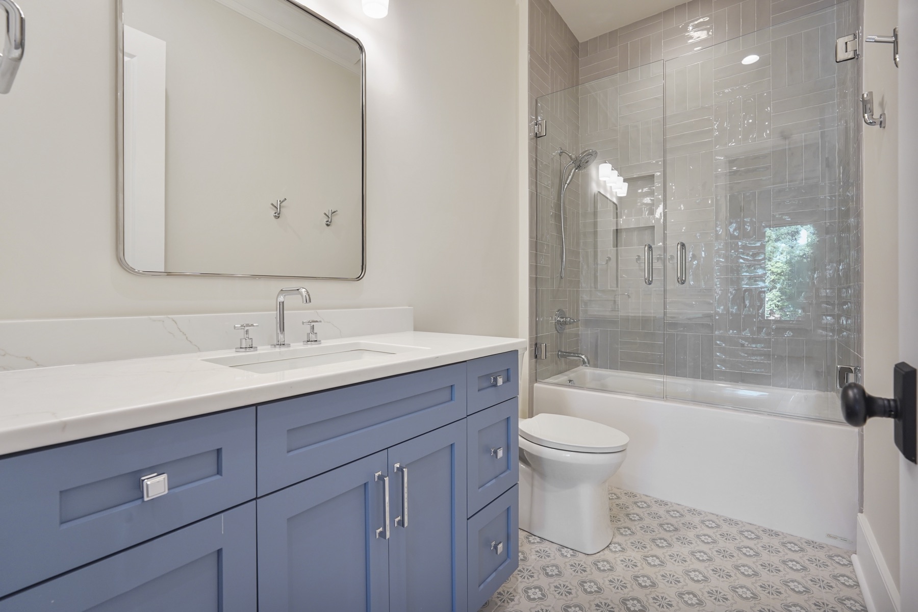 Bathroom with a blue vanity and glass shower