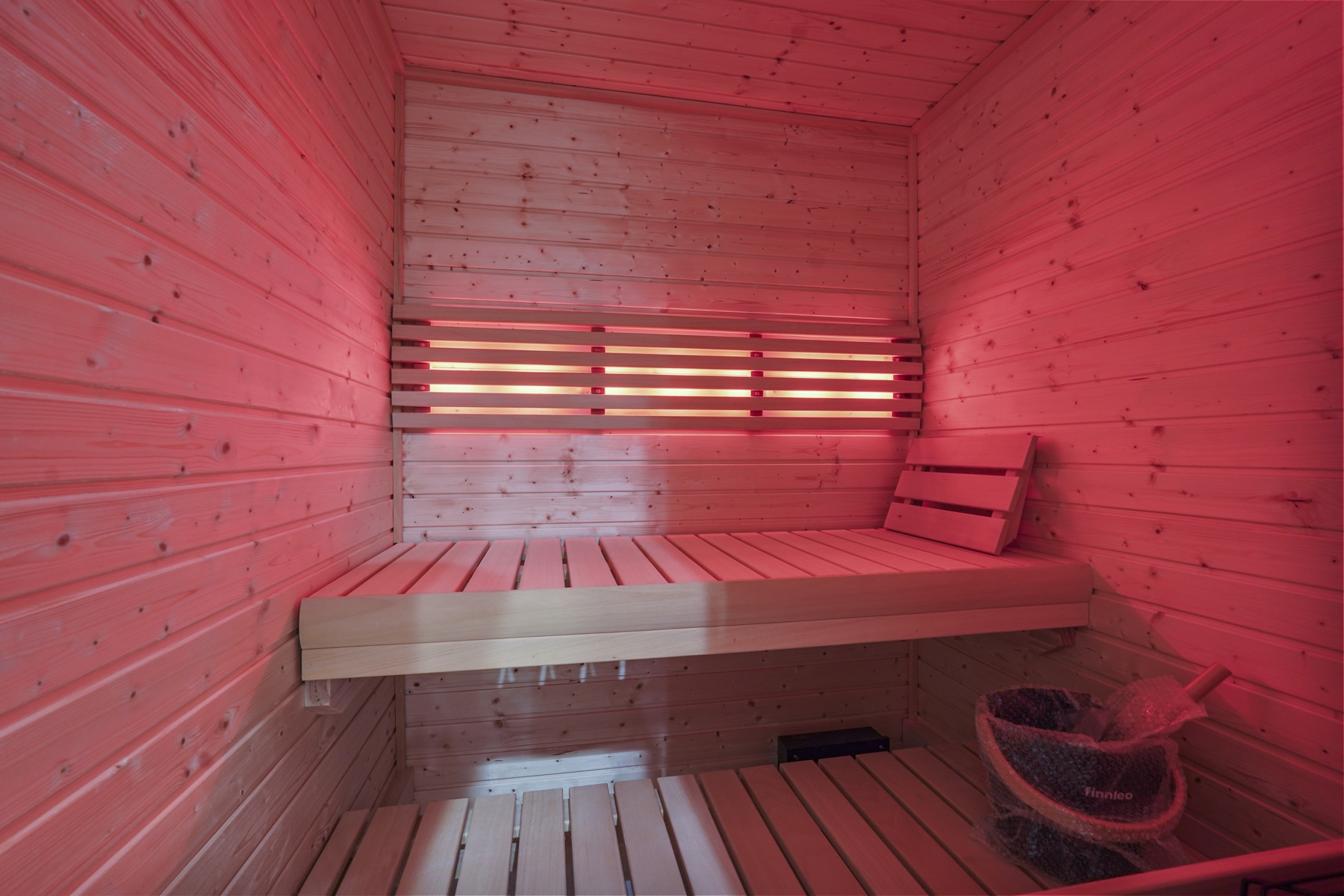 Wood-paneled sauna with red lighting