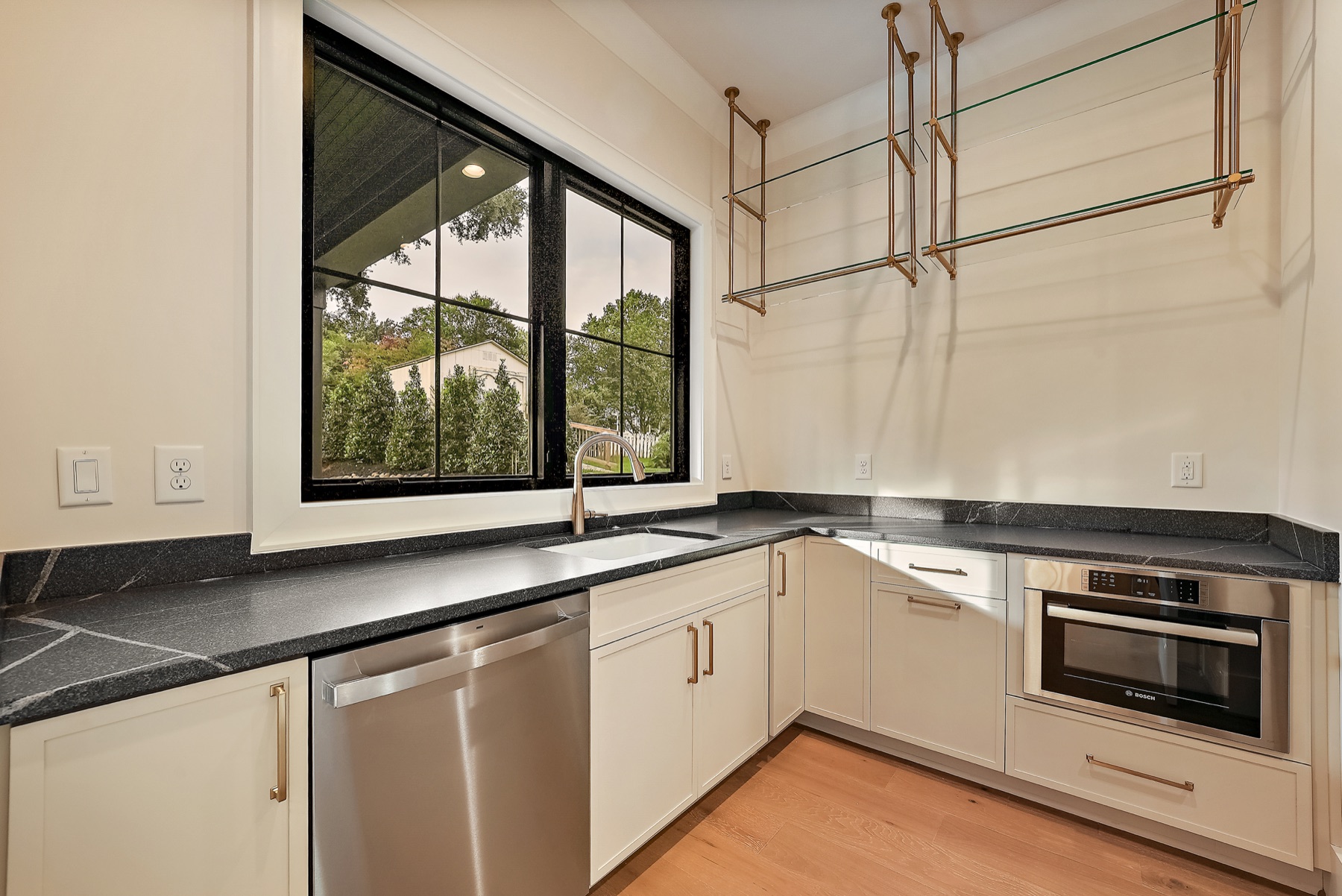 Custom kitchen with light cabinetry and dark countertops