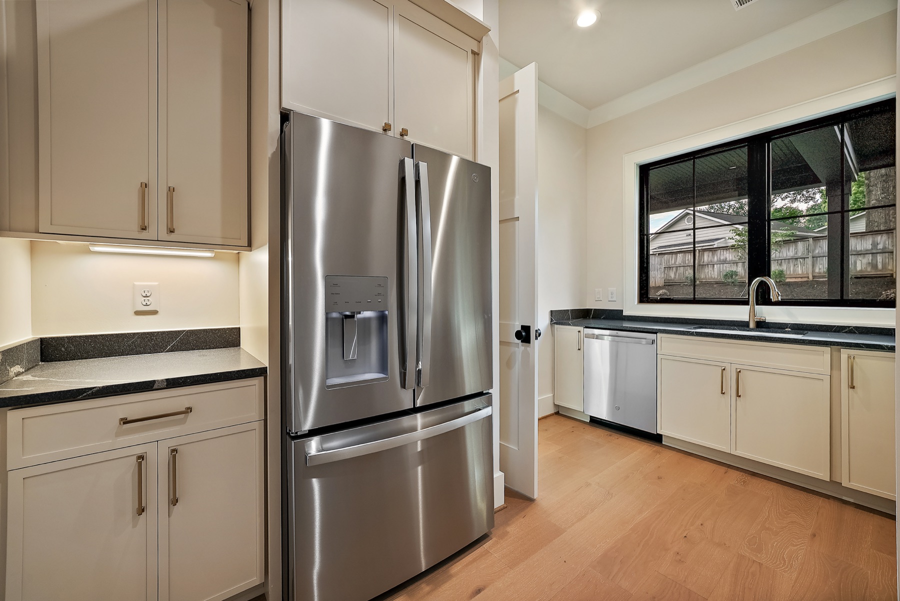 Kitchen with stainless steel appliances and black framed windows