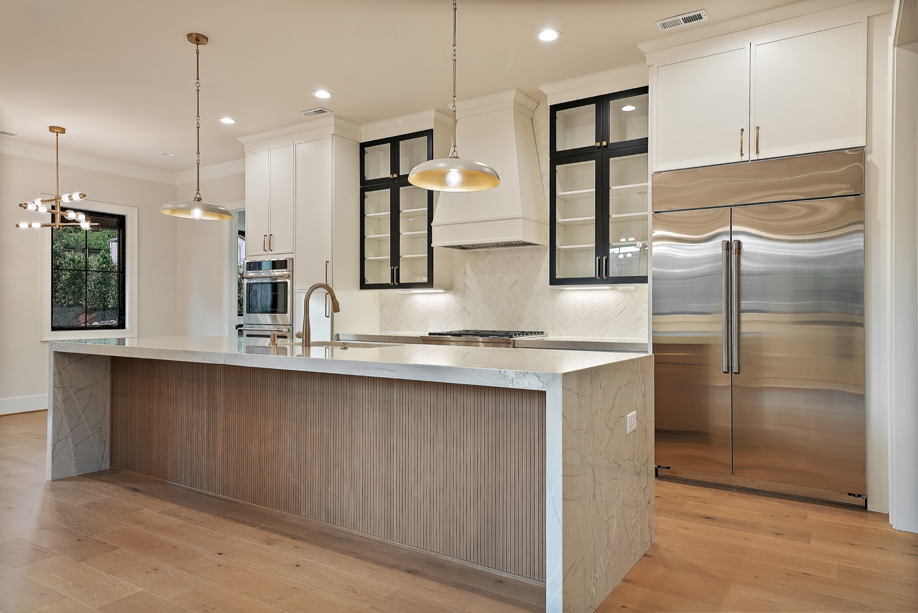 Kitchen island with wood cabinetry and pendant lights