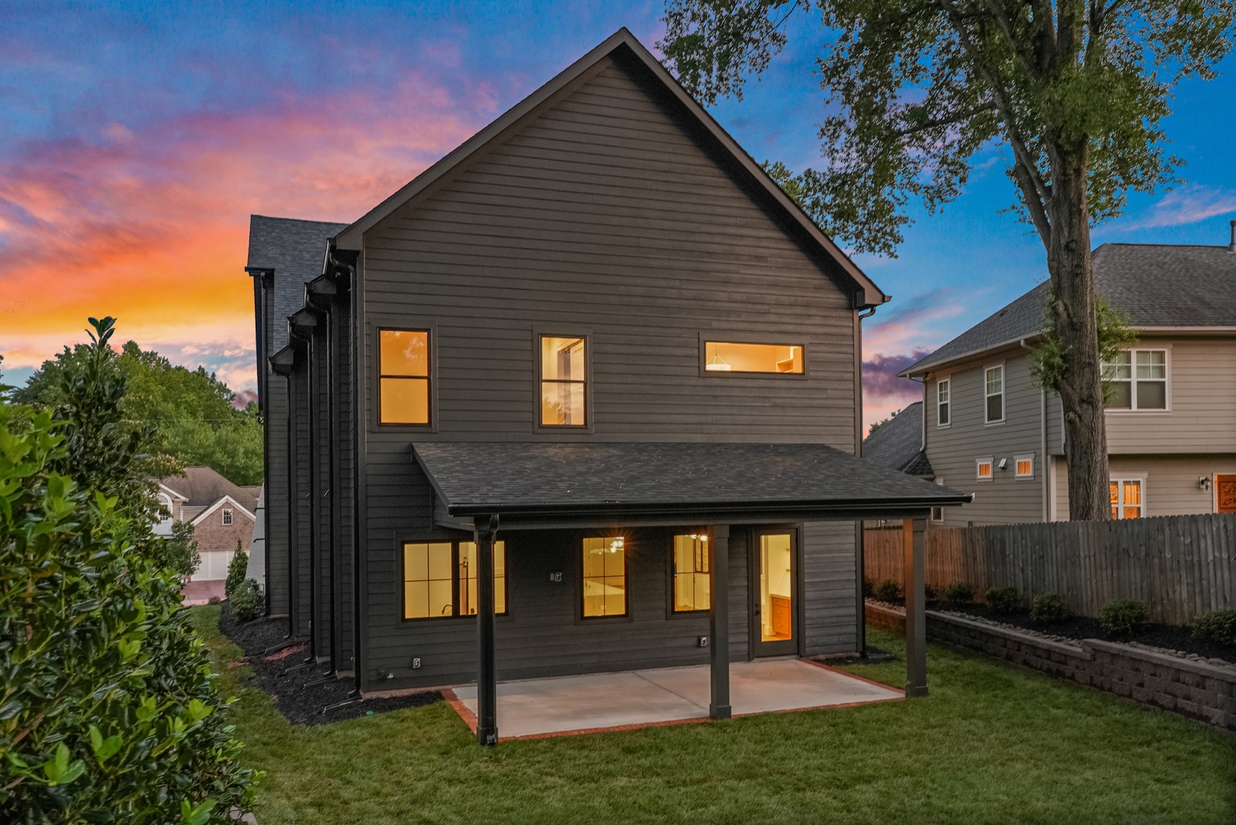 Rear exterior and lawn of a BWA Builders custom home at dusk